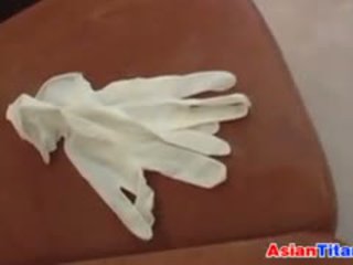 An ázijské gives a robenie rukou s latex rukavice